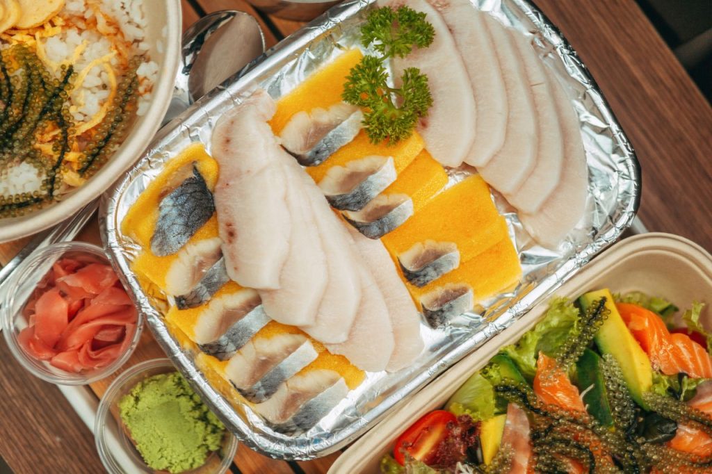 A vibrant sushi platter featuring fresh slices of sashimi, seaweed salad, and garnishes, perfect for seafood lovers.